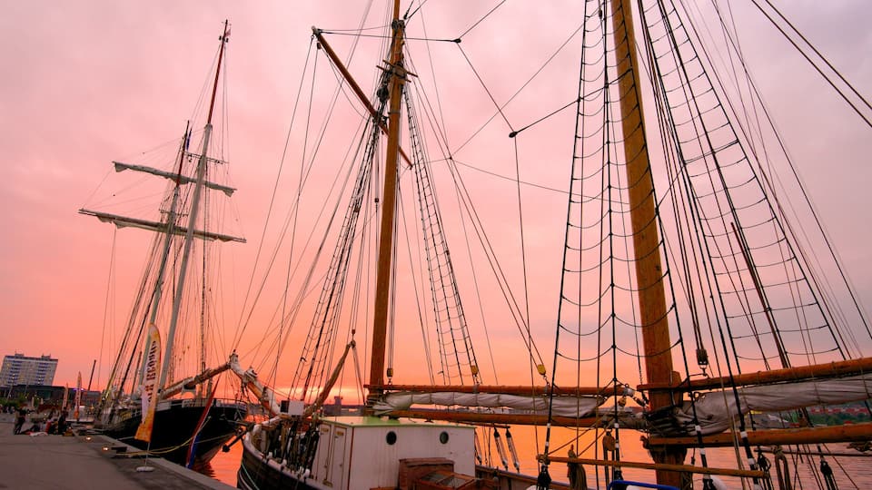 Aalborg mostrando un atardecer, una bahía o un puerto y botes