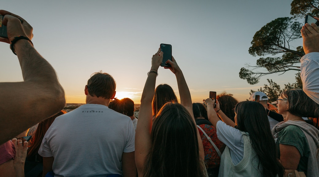 Pincio Terrace showing views and a sunset as well as a small group of people