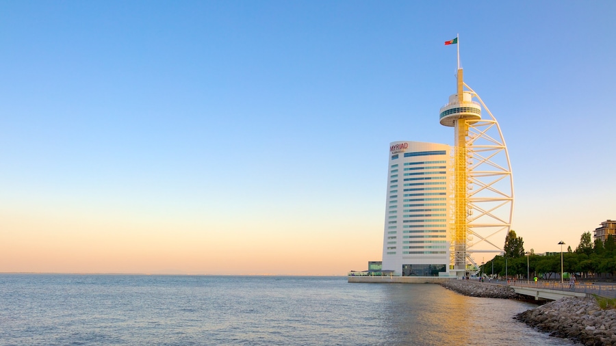 Vasco da Gama Bridge which includes modern architecture, a sunset and general coastal views
