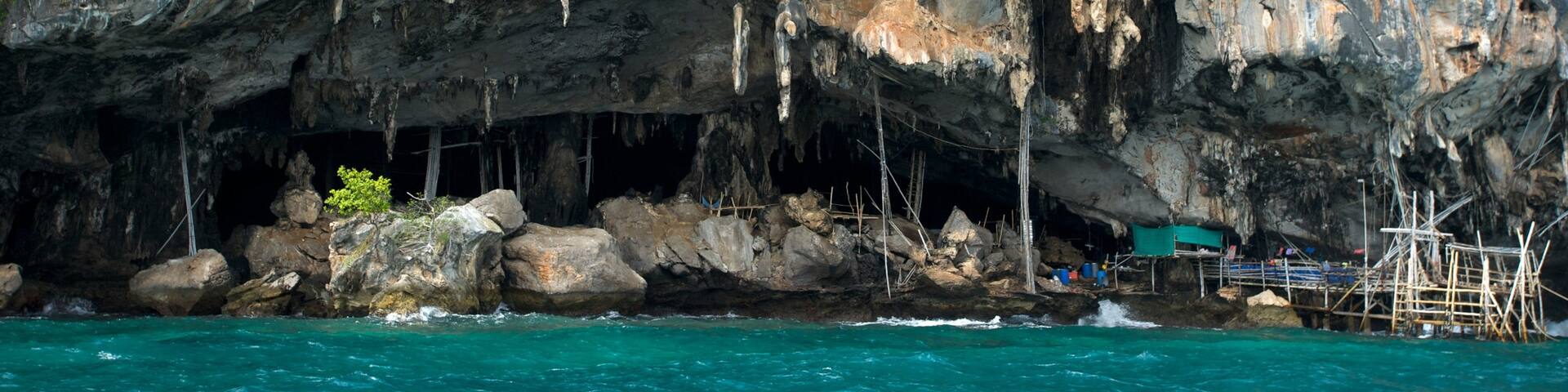 Maya Bay showing caves, rocky coastline and a bay or harbor