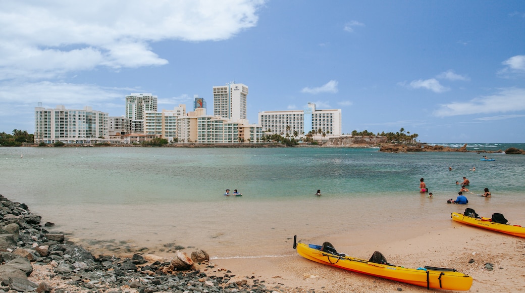 Condado Beach which includes a sandy beach, a coastal town and general coastal views