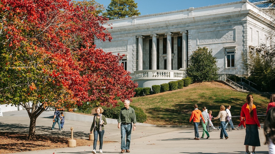 Visitors exploring Zoo Atlanta with autumn foliage and historic architecture.