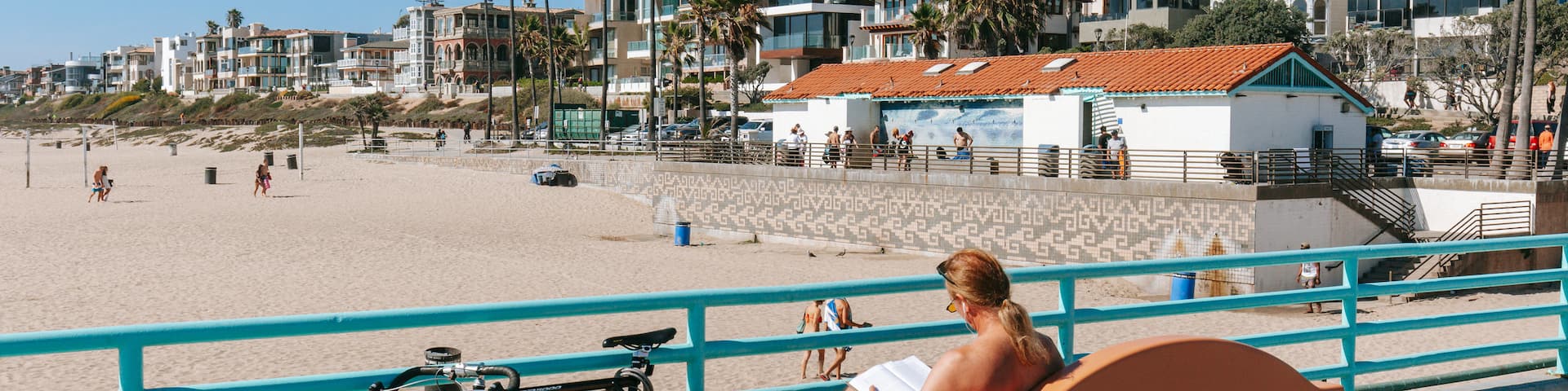 Manhattan Beach which includes a sandy beach and a coastal town as well as an individual male