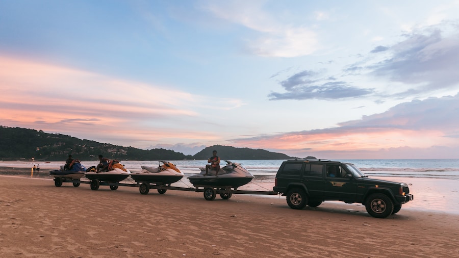 Patong Beach showing off road driving, a sunset and a sandy beach