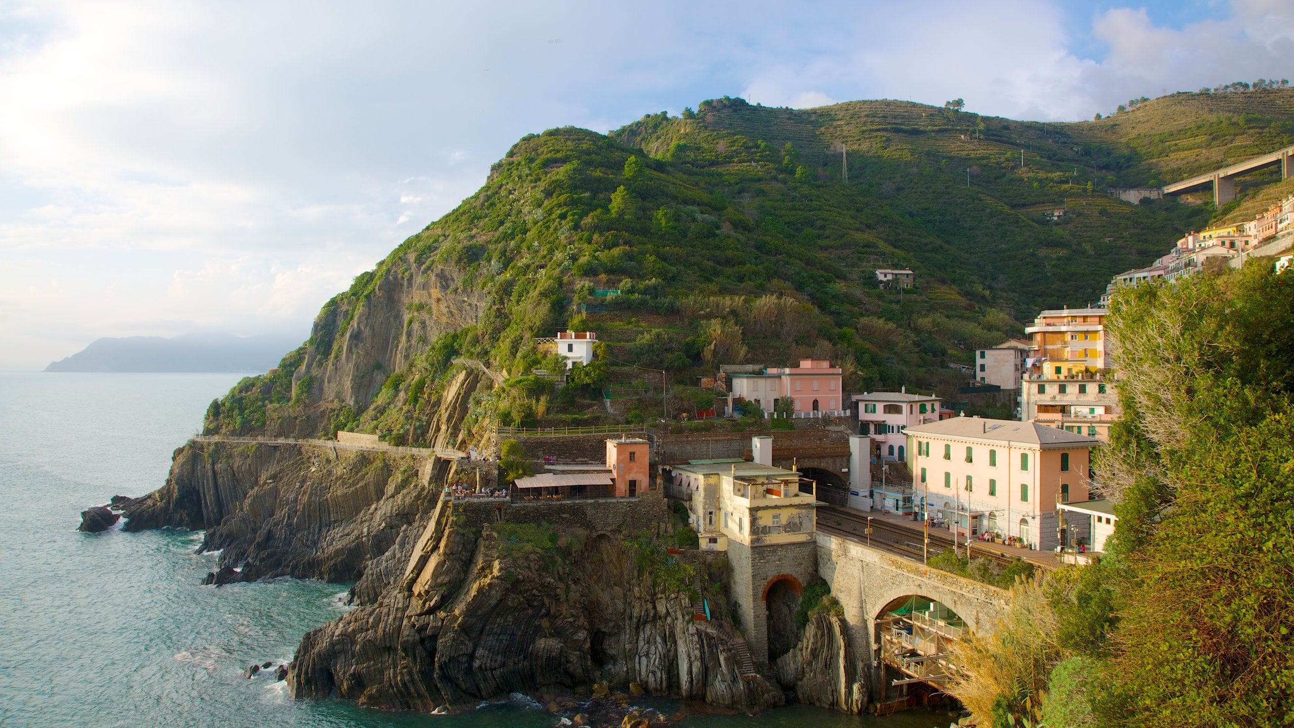 Riomaggiore which includes a coastal town, mountains and rugged coastline