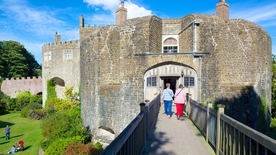 Castello e giardini di Walmer che include ponte e castello cosi come un piccolo gruppo di persone