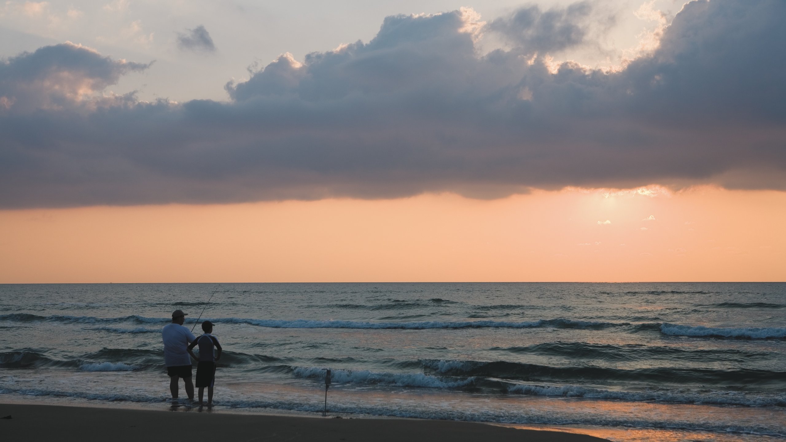 South Padre Island featuring a sandy beach, fishing and a sunset