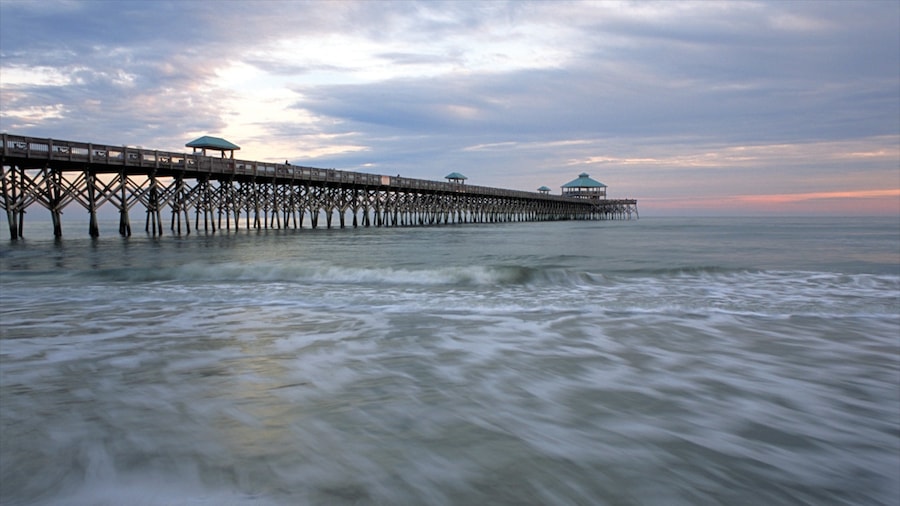 Folly Beach featuring a bridge, a sunset and a sandy beach