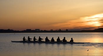 Boulder which includes a sunset and kayaking or canoeing as well as a large group of people