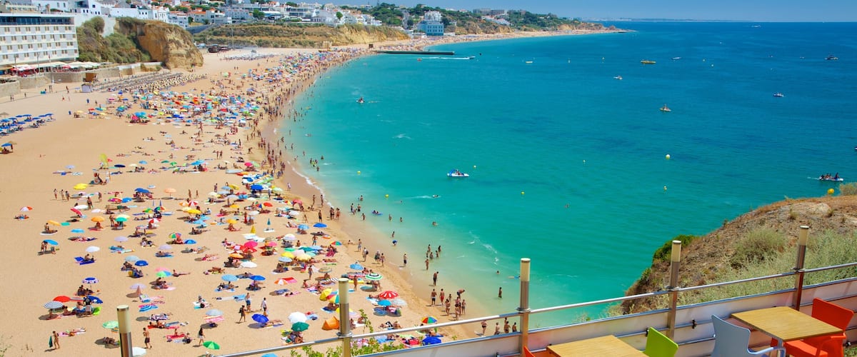 Albufeira mostrando una ciudad costera, natación y una playa de arena