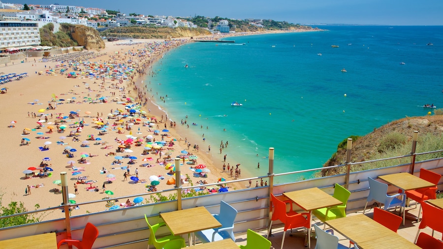 Albufeira mostrando una ciudad costera, natación y una playa de arena