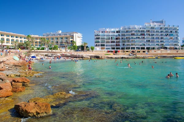 Plage de Caló des Moro montrant baignade, ville côtière et hôtel ou complexe de luxe