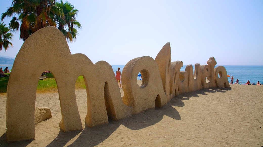 Malagueta Beach featuring signage and a sandy beach