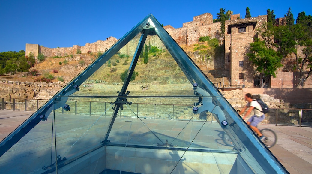 Malaga Amphitheatre showing heritage architecture and cycling as well as an individual male
