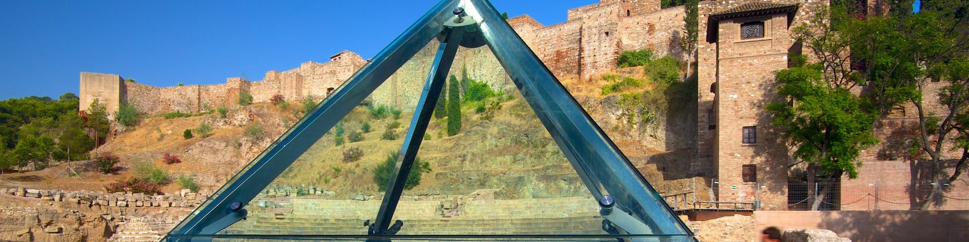 Malaga Amphitheatre showing heritage architecture and cycling as well as an individual male