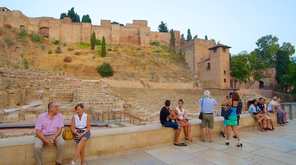 Malaga Amphitheatre showing a ruin and heritage architecture as well as a large group of people