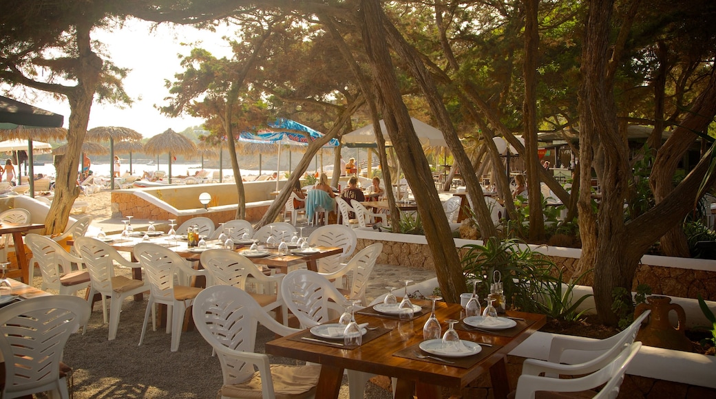 Cala Jondal Beach featuring outdoor eating, a coastal town and a sunset