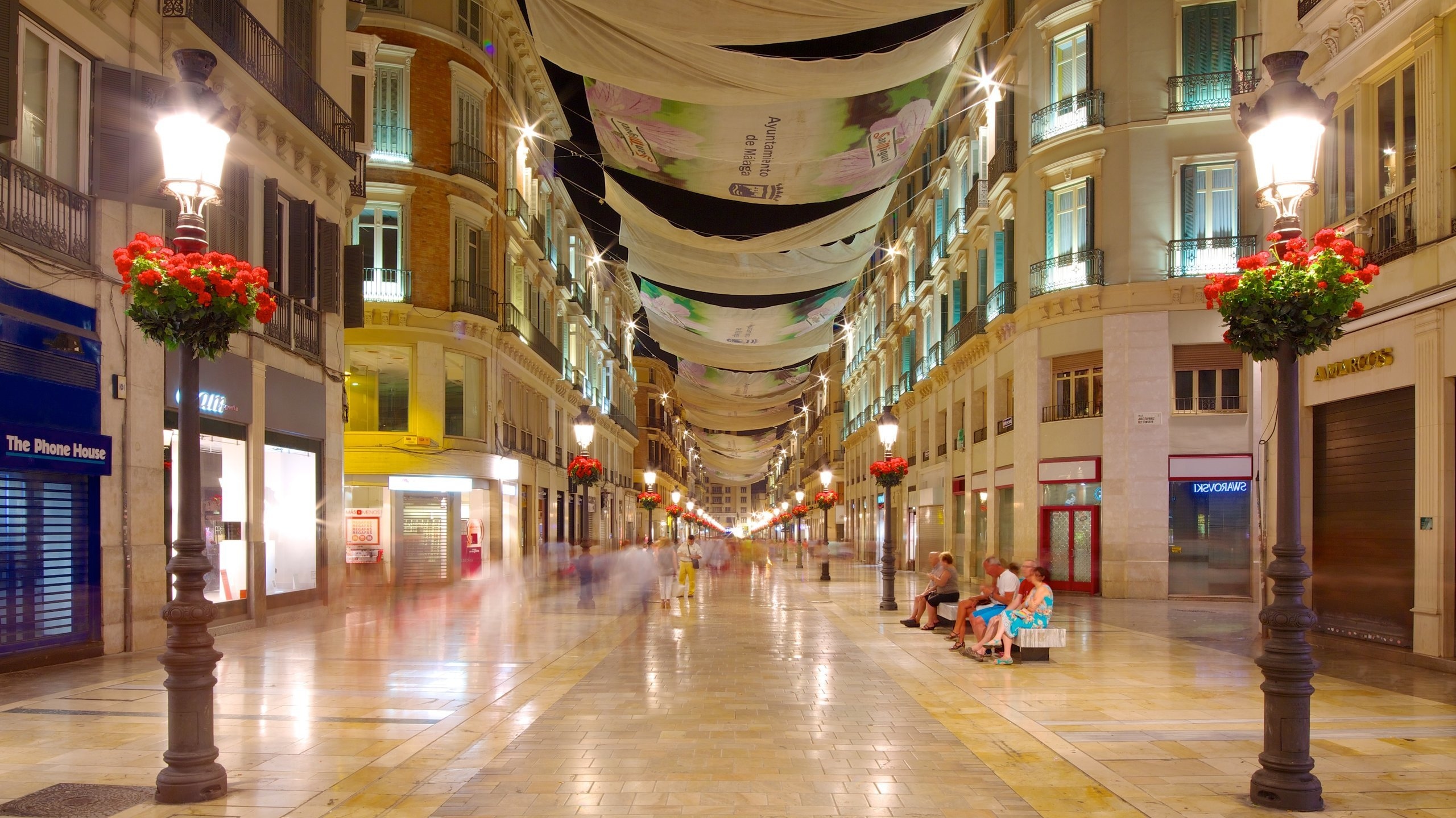 Malaga Historic Centre showing modern architecture as well as a small group of people