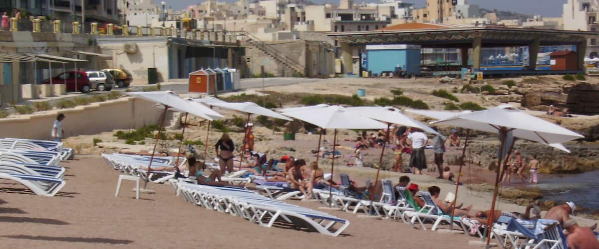 Bugibba som inkluderar en kuststad och en sandstrand sÄvÀl som en stor grupp av mÀnniskor