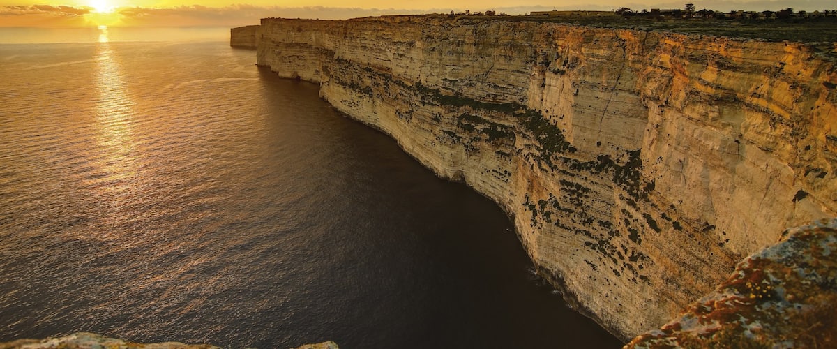 Gozo showing rugged coastline, a sunset and landscape views