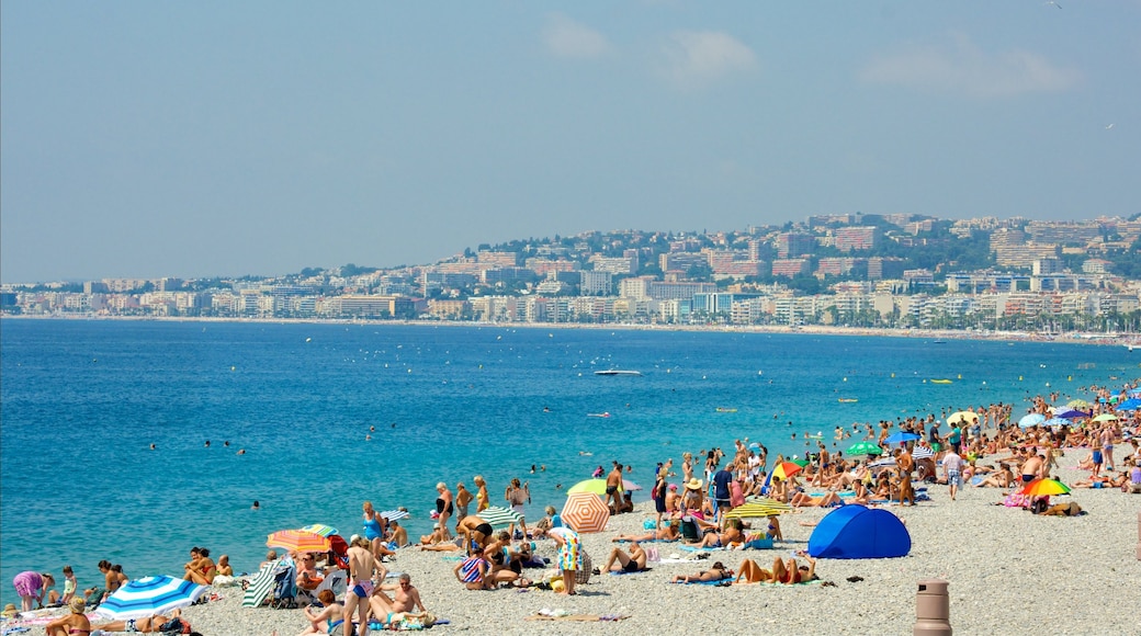 Nice mettant en vedette ville côtière et plage de sable aussi bien que important groupe de personnes