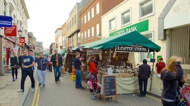 Colchester featuring markets and signage as well as a large group of people