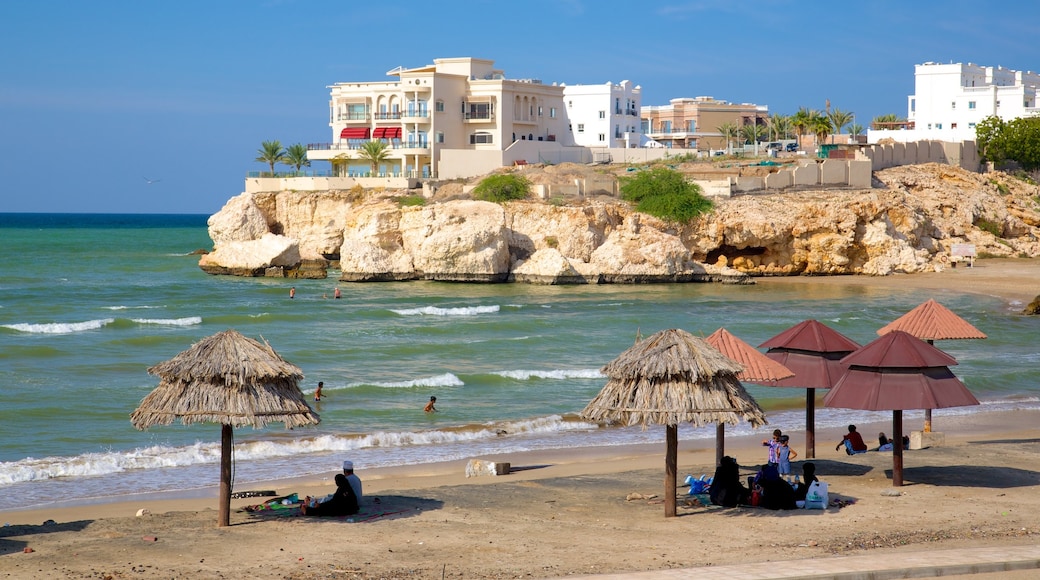 Shatti Al-Qurum mostrando una ciudad costera, una playa de arena y vistas generales de la costa