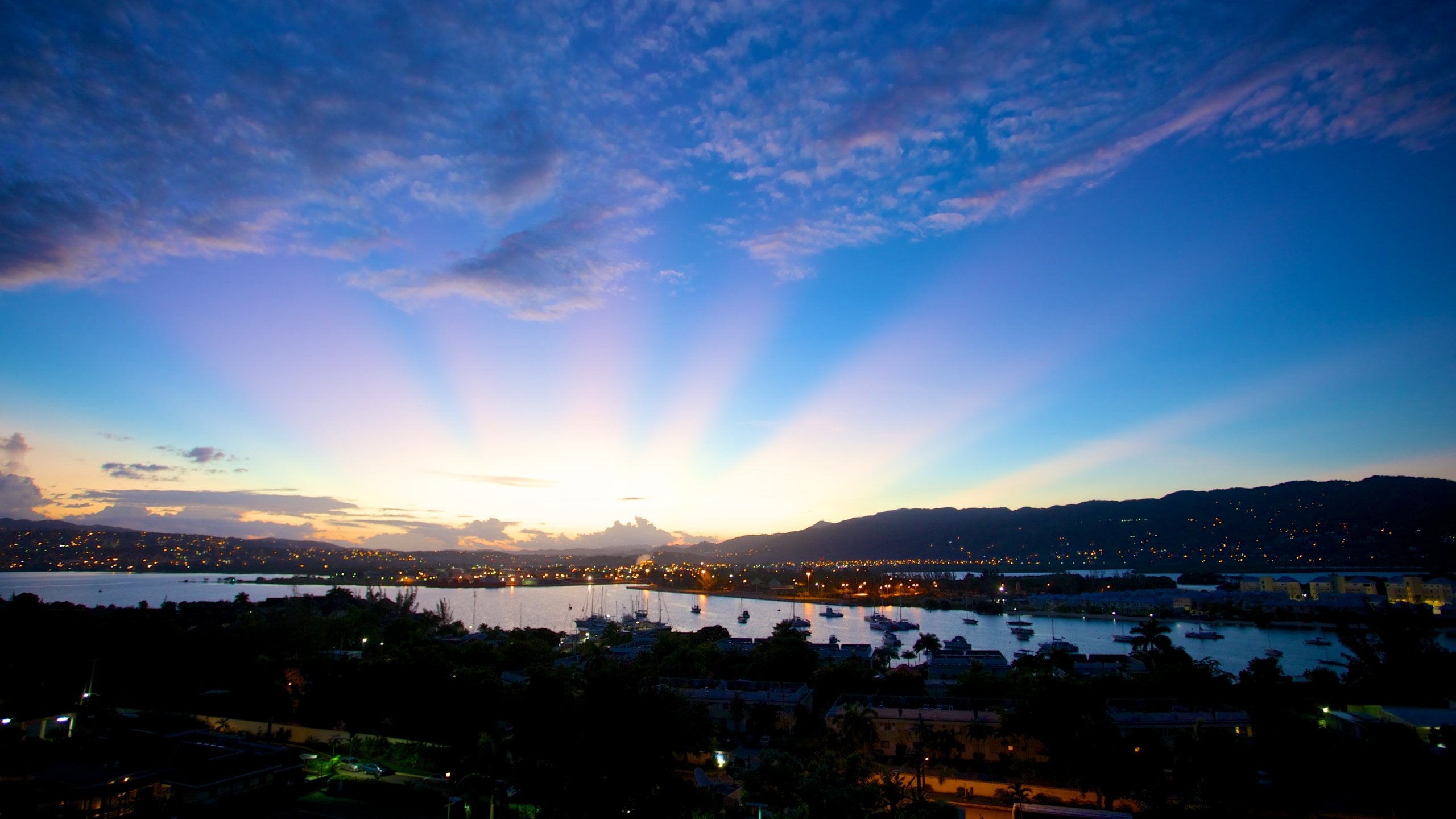 Bahía Montego que incluye una ciudad, una puesta de sol y una bahía o puerto