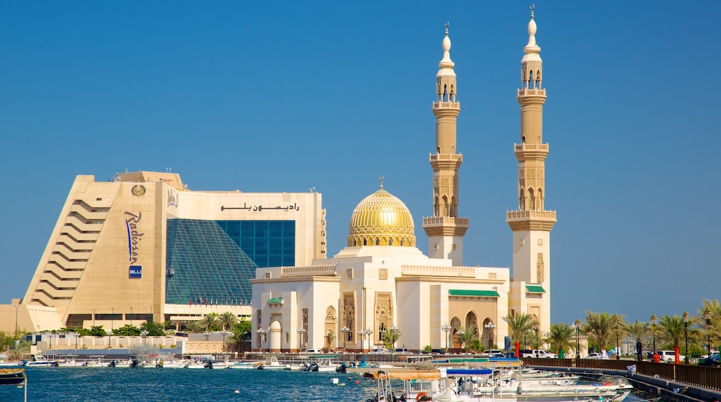 Sharjah presenterar båtkörning, en moské och en hamn eller havsbukt