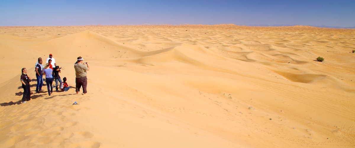 Désert de Dubaï qui includes vues du désert aussi bien que petit groupe de personnes