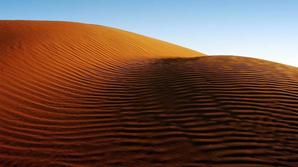 Abu Dhabi som inkluderar landskap, öknar och en solnedgång