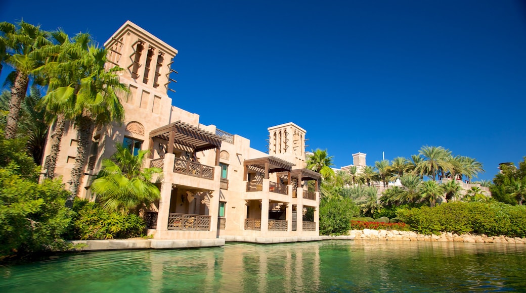 Souk Madinat Jumeirah som visar historisk arkitektur, en damm och tropisk natur