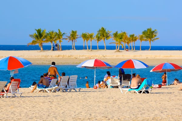 Parc et plage Al Mamzar mettant en vedette scĂšnes tropicales et plage de sable aussi bien que important groupe de personnes