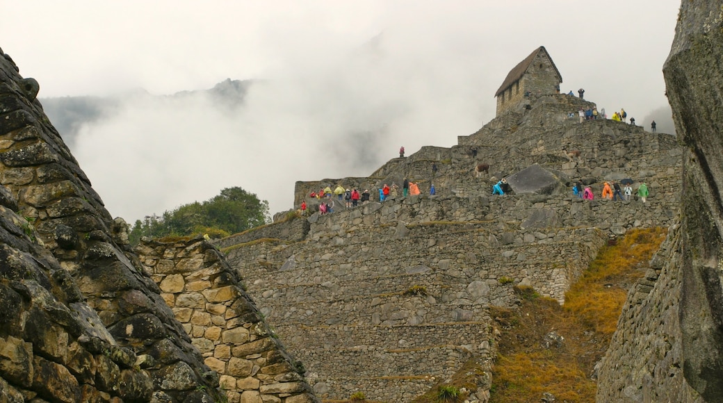 Machu Picchu which includes hiking or walking, a ruin and mist or fog