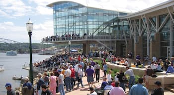 Downtown Dubuque featuring modern architecture and a river or creek as well as a large group of people