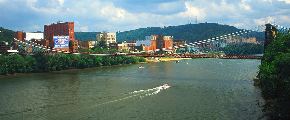 Wheeling featuring a river or creek, a city and a suspension bridge or treetop walkway