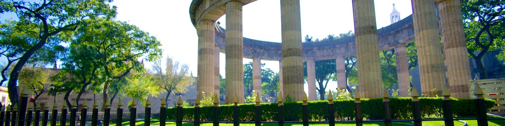 Rotonda de los Hombres Ilustres featuring a garden, a memorial and heritage architecture