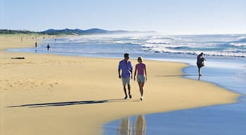 Coolum Beach showing landscape views and a beach as well as a couple