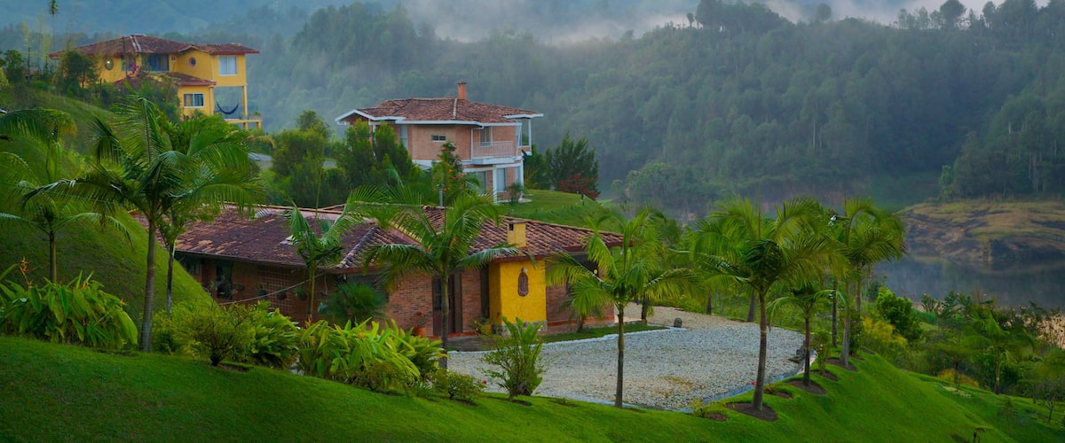Rock of Guatape featuring tranquil scenes, a house and mist or fog