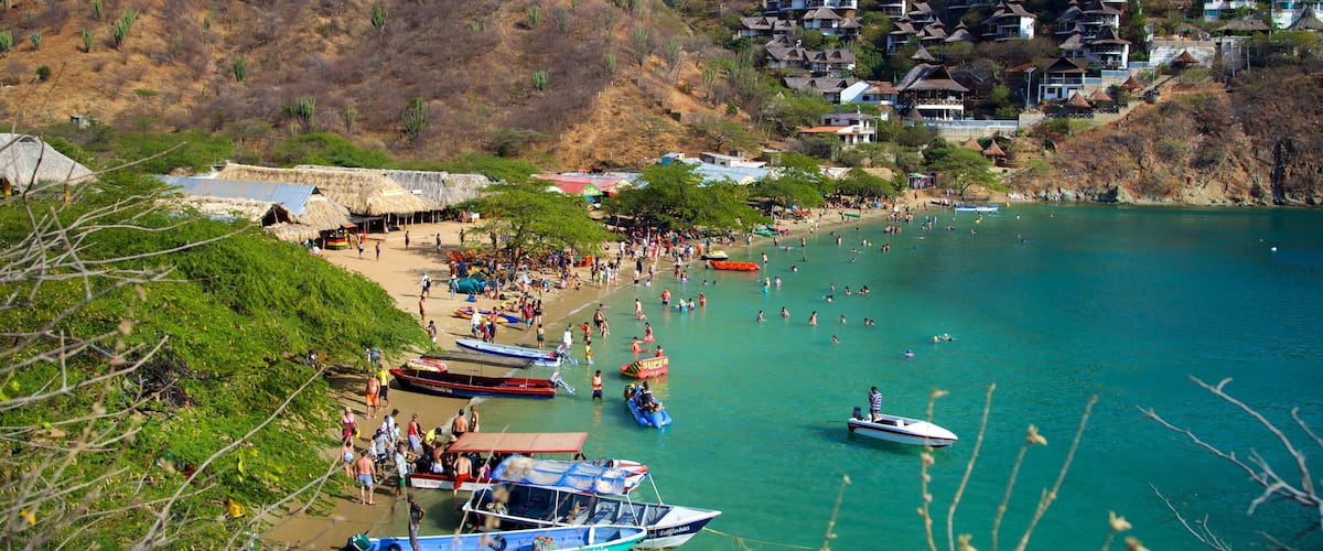 Playa Taganga ofreciendo una ciudad costera, una playa y una bahía o puerto