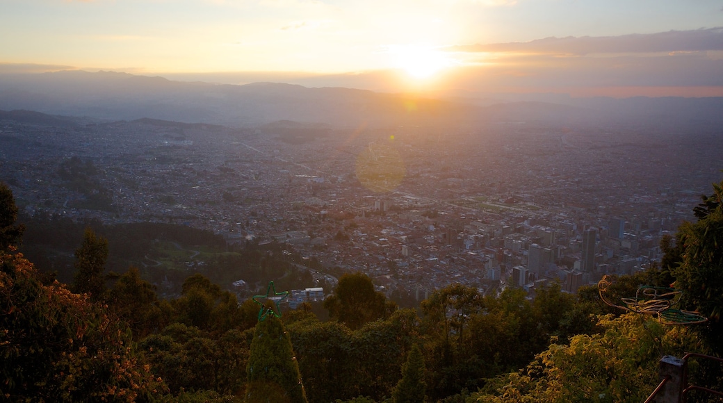 Monserrate que inclui um pôr do sol, uma cidade e paisagem