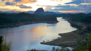 Rock of Guatape which includes a sunset, landscape views and forest scenes