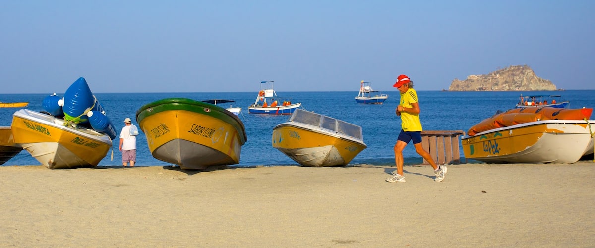 Rodadero Beach featuring boating and a beach as well as an individual male