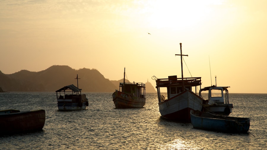 Taganga Beach which includes a sunset, boating and a bay or harbor
