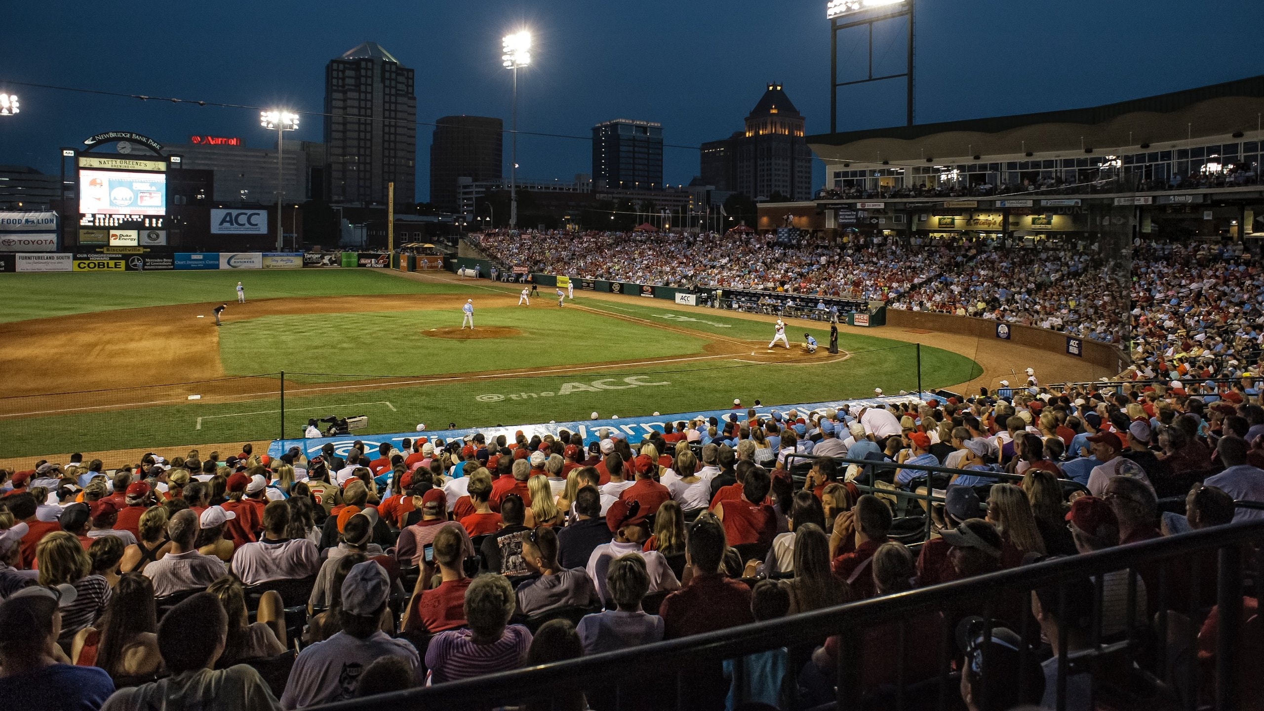 Greensboro featuring a sporting event and night scenes as well as a large group of people