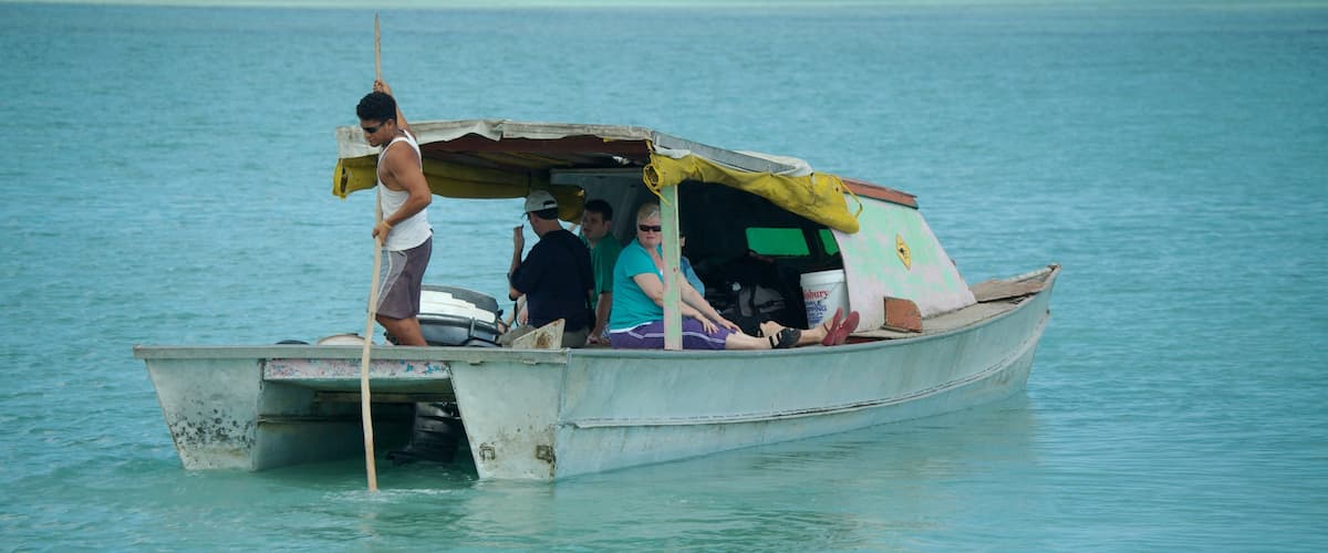 Manono que inclui canoagem e cenas tropicais assim como um pequeno grupo de pessoas