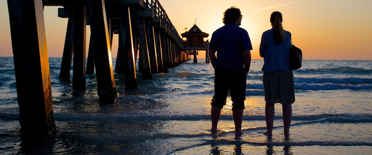 Naples Pier ofreciendo vistas, una puesta de sol y una playa