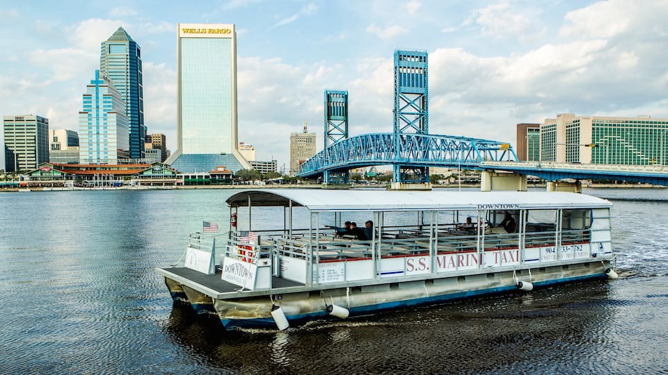 Centro de Jacksonville mostrando una ciudad, un ferry y un río o arroyo