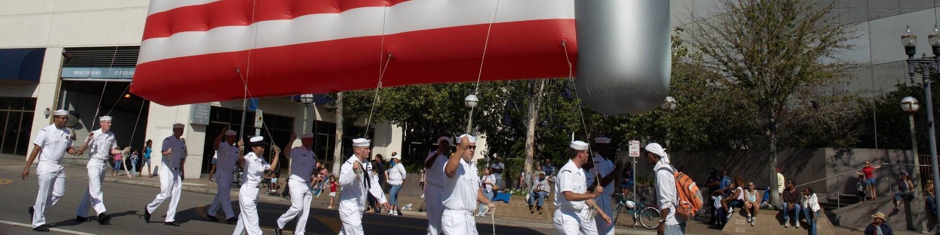 Downtown Jacksonville showing a festival and military items as well as a large group of people