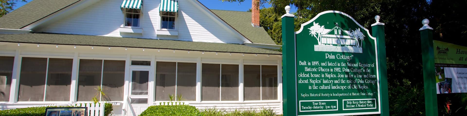 Naples Historical Society\'s Historic Palm Cottage featuring signage and a house